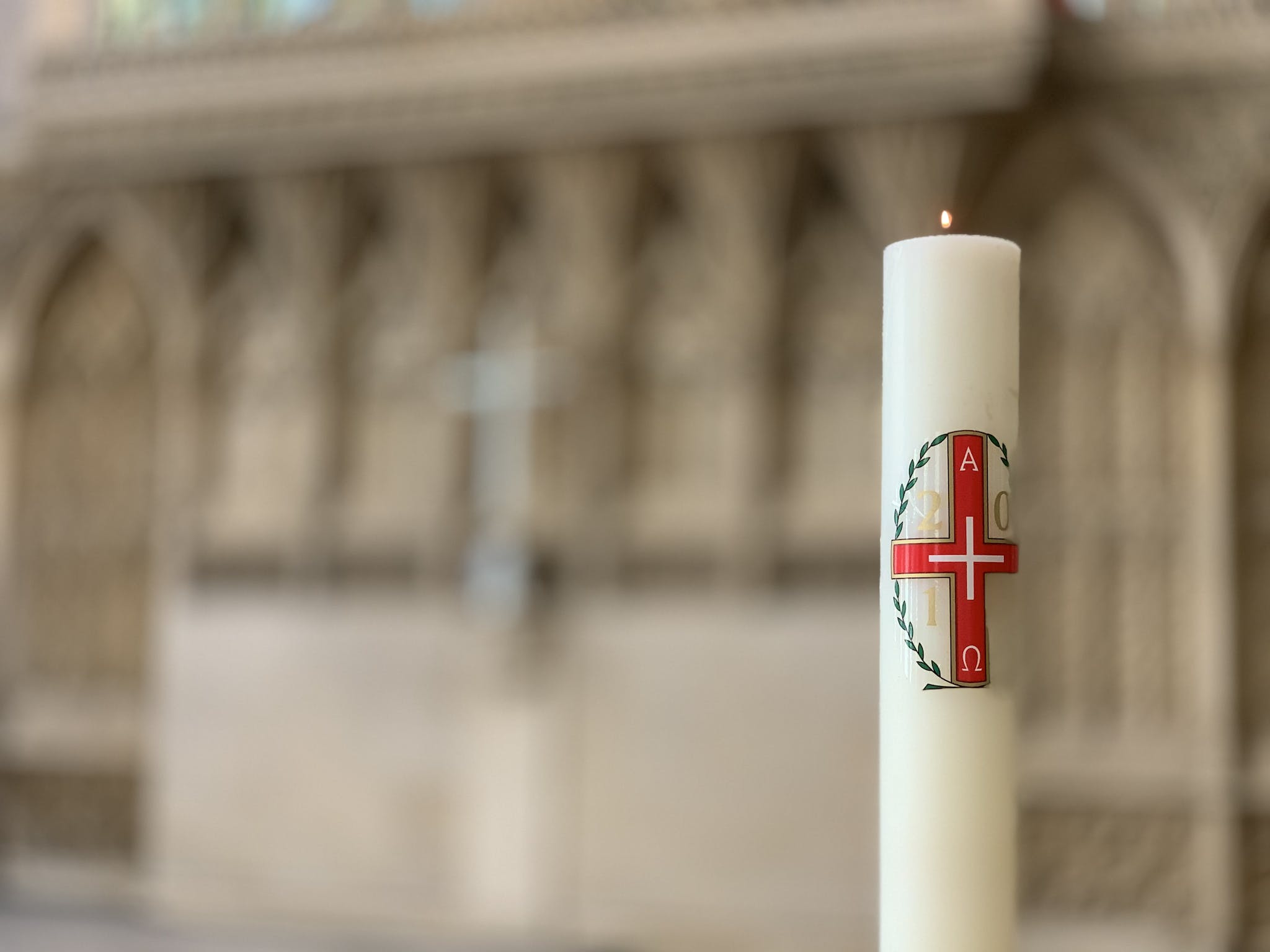 Burning candle with red cross